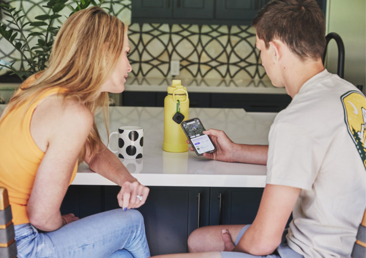 Two people sitting at a counter looking at a phone